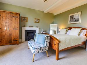 a bedroom with a bed and a chair at Goss Hall in Canterbury