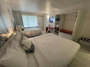 una camera d'albergo con due letti e una televisione di Newly Room in cozy hotel with Super location to the Parks a Kissimmee