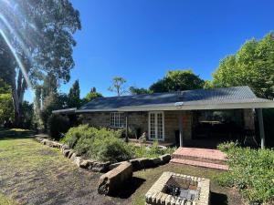 una casa con un giardino davanti di Periwinkle, Grove ,Acorn & Sage Cottages a Clarens