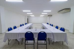 a conference room with a long table and blue chairs at Hotel Axis Inn By GEH Suites in Santa Marta