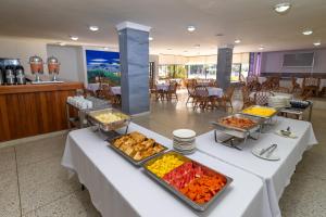 a buffet of food on a table in a restaurant at Hotel Axis Inn By GEH Suites in Santa Marta