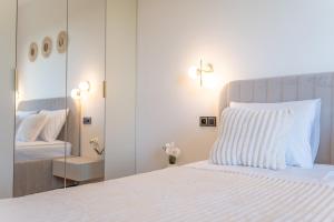 Un dormitorio con una cama blanca y un espejo. en K&M Apartments Near Tauron Arena, en Cracovia