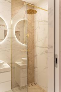 una ducha con puerta de cristal en un baño en K&M Apartments Near Tauron Arena, en Cracovia 21 fotos más
