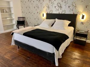 a bedroom with a large bed with a black and white comforter at Suite Clos Ahimsa in Volnay