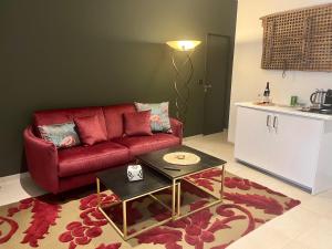 a living room with a red couch and a table at Suite Clos Ahimsa in Volnay