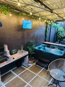 a patio with a hot tub and a table and a sink at Casa Caribe in Guápiles