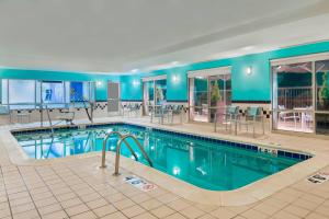 una piscina en un hotel con mesas y sillas en SpringHill Suites Indianapolis Carmel, en Carmel