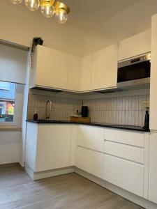 a kitchen with white cabinets and a sink at Casa vacanze Daiva in Arona +18 photos