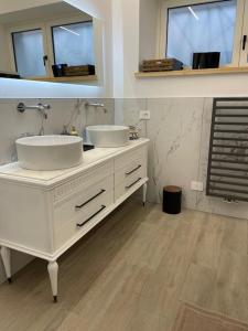 a white bathroom with two sinks and a mirror at Casa vacanze Daiva in Arona