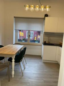 a kitchen with a wooden table and chairs and a table and a counter at Casa vacanze Daiva in Arona