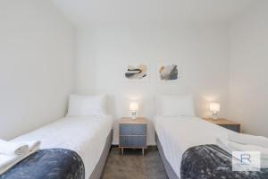 オークランドにあるExecutive city-fringe Townhouseのランプ2つが備わる客室で、ツインベッド2台が付いています。