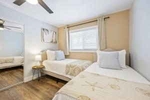 une chambre avec deux lits et une fenêtre dans l'établissement The Shark Tank Cocoa Beach - Coastal Modern, Downtown, 5-Min Walk to Beach, Shops & Bars, à Cocoa Beach