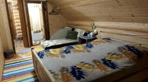 a bedroom with a bed in a log cabin at У Медовому Раю in Rostoka