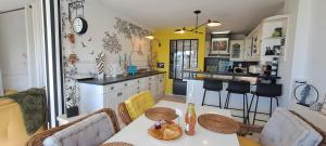 eine Küche mit Tisch und Stühlen in einem Zimmer in der Unterkunft Appartement terrasse esprit loft vue sur mer in Erquy + 52 Fotos