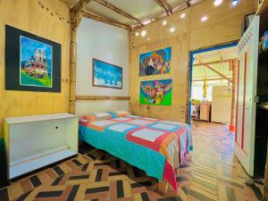 a bedroom with a bed and paintings on the walls at Los Gulungos Hostel in Jardin +20 photos