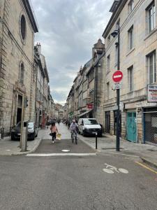 a couple of people riding a bike down a city street at Studio centre-ville in Besançon