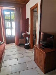 sala de estar con TV y suelo de baldosa. en Konstantinou & Elenis, en Monodendri