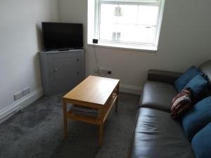 ein Wohnzimmer mit einer Couch und einem Couchtisch in der Unterkunft Centrally located, beautifully presented apartment in Torquay