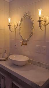 a bathroom with a sink and a mirror and lights at Hotel e Pousada O Casarão in Palmeiras +20 photos