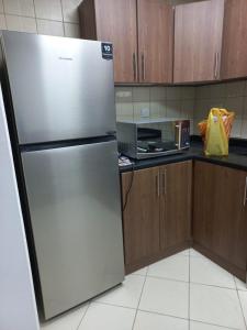 a stainless steel refrigerator in a kitchen with wooden cabinets at عجمان تارو 7 in Ajman 
