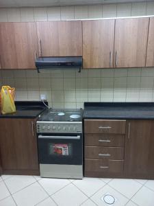 a kitchen with a stove and a counter top at عجمان تارو 7 in Ajman 