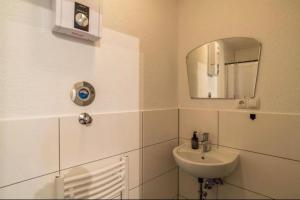 a white bathroom with a sink and a mirror at Appartio - Apartment für 2 - Küche - WiFi - Altstadtlage in Worms +12 photos