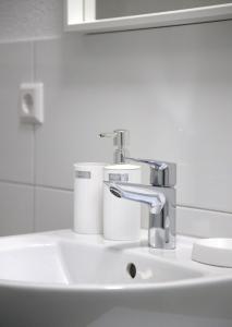 a bathroom sink with a faucet and toilet paper at Smart 1 in Tuttlingen