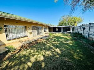 a backyard of a house with a fence at Kelello House House in Welkom