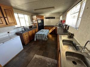 a kitchen with a sink and a table in it at Kelello House House in Welkom