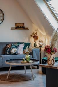 a living room with a blue couch and a table at Appartement 3 haasjes in landelijke omgeving in Wijdenes