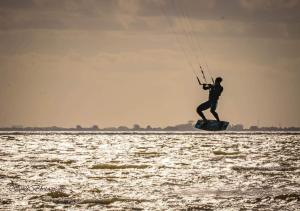 a man is on a board in the water at Appartement 3 haasjes in landelijke omgeving in Wijdenes