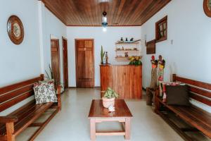 a living room with benches and a table and a door at Pousada Ponta da Baleia in Barra Grande