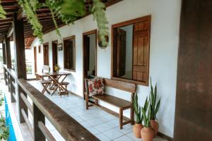 a porch of a house with a bench and a table at Pousada Ponta da Baleia in Barra Grande