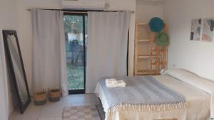 チャパドマラルにあるLa Surfina en Chapadmalalのベッドと大きな窓のある寝室