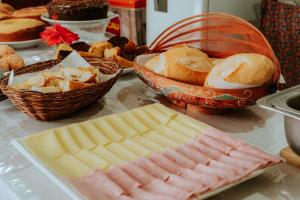 a table with baskets of bread and baskets of pastries at Pousada Ponta da Baleia in Barra Grande