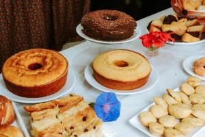 a table topped with different types of cakes and pastries at Pousada Ponta da Baleia in Barra Grande