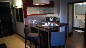 a kitchen with a counter and chairs in a room at Art Apartment Szczecin in Szczecin