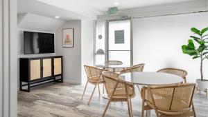 a living room with a table and chairs and a tv at Leland Hotel Palo Alto in Palo Alto