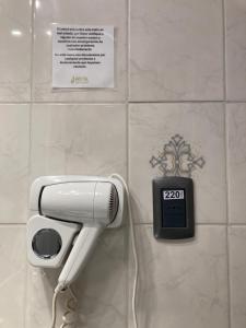 um secador de cabelo e um telefone na parede em Hostal Loreto Belen em Puerto Natales