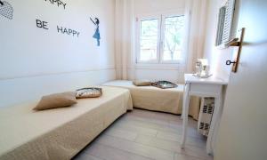 two beds in a small room with a window at Appartamento Peschiera in Peschiera del Garda