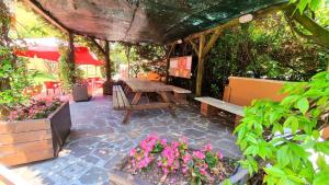 a patio with a wooden picnic table and flowers at Appartamento Peschiera in Peschiera del Garda