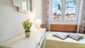 a bedroom with a bed with a lamp and a window at Appartamento Peschiera in Peschiera del Garda +41 photos