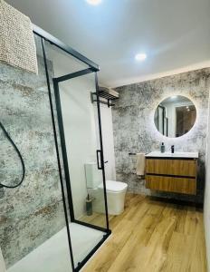 Un baño con ducha, lavabo y espejo. en Gran apartamento a pie de calle, en Valencia