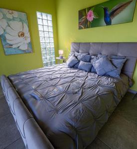 een slaapkamer met een groot bed met blauwe kussens bij Finca Colibri in Boca Chica