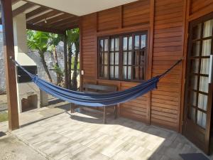 a hammock on the outside of a house at Casa Colonial em Guaratuba, próximo a praia in Guaratuba