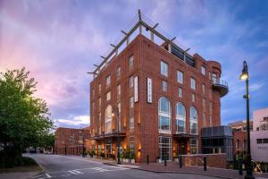 a large red brick building on a city street at The Alida, Savannah, a Tribute Portfolio Hotel in Savannah