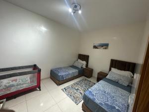 a bedroom with two beds and a ceiling at Apartment am Meer mit Pool in Aourir +5 photos