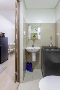 une salle de bain avec un lavabo, des toilettes et un miroir dans l'établissement Oasis Urban Stay 2, à Manille