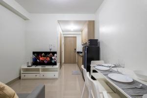 une cuisine avec un réfrigérateur noir et une télévision dans l'établissement Oasis Urban Stay 2, à Manille