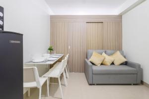 un salon avec un canapé et une table avec des chaises dans l'établissement Oasis Urban Stay 2, à Manille